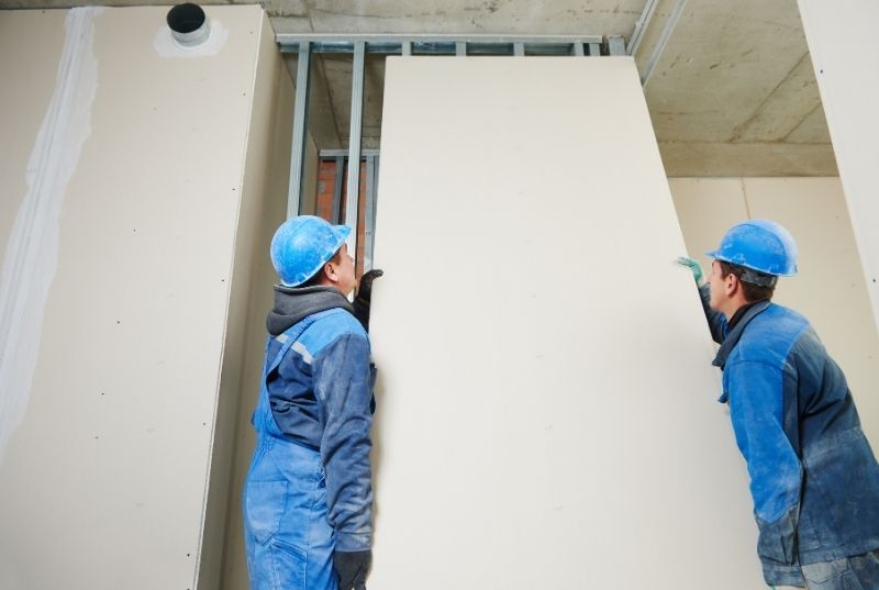 Two Newcastle Plasterer installing a gyprock plasterboard wall on a metal framing